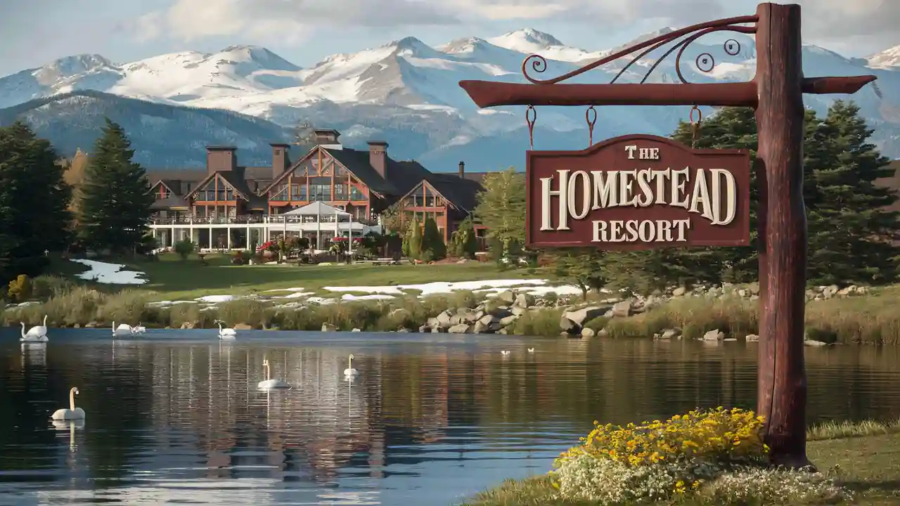 Top 15 Cheap Weekend Getaways in Michigan for Couples in 2025 11 A scenic view of The Homestead Resort sign, with a picturesque lodge building, pond, and mountains in the background. The pond reflects the building and snowy peaks while swans float on the water, surrounded by greenery and yellow flowers in the foreground.
