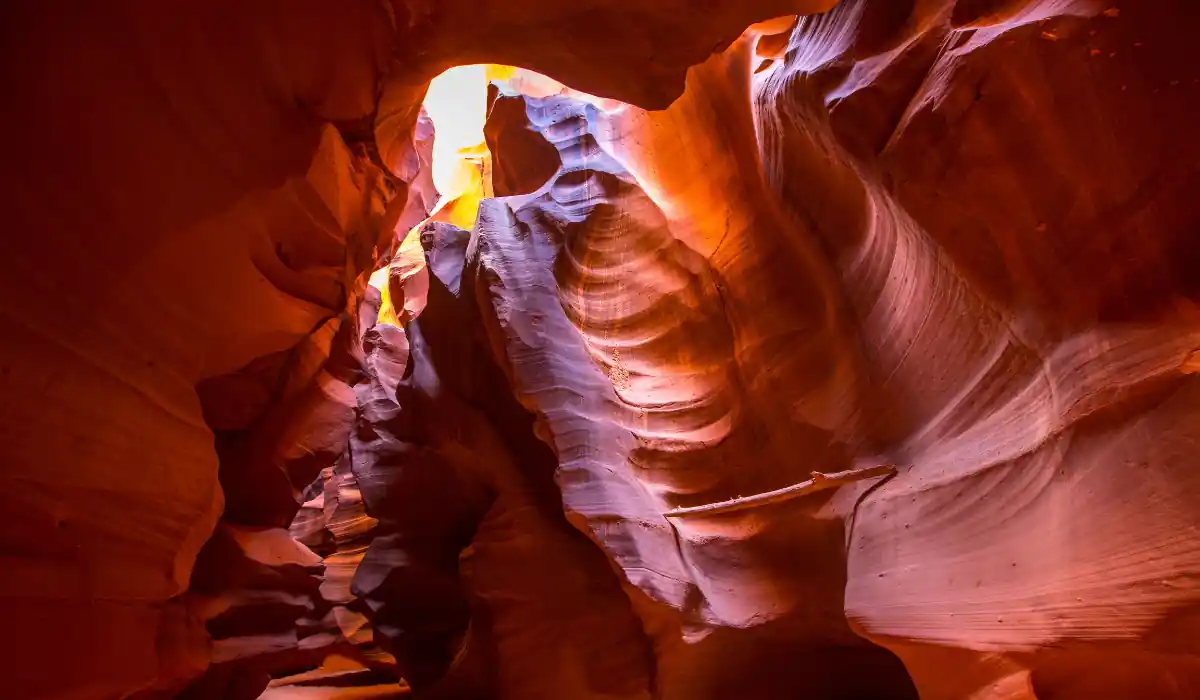 Top 15 Fun $ Unique Places That Don't Feel Real in the USA 2025 6 A stunning view of Antelope Canyon, showcasing smooth, swirling sandstone formations illuminated by warm sunlight. The light creates a dramatic contrast of shadows and highlights, highlighting the natural curves and textures.