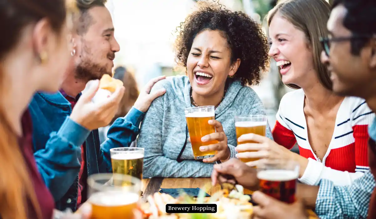 Top 15+ Romantic Things to do in Portland for Couples 15 A group of five friends laughing and enjoying beers around a table outdoors. They seem relaxed and are having a good time together. The setting is casual and lively.