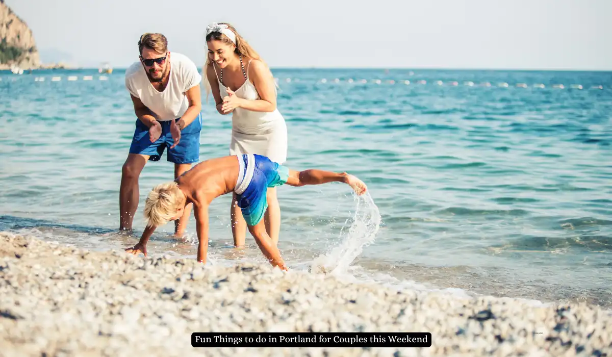Top 15+ Romantic Things to do in Portland for Couples 13 A couple watches their child play on a rocky beach by the sea. The child is doing a cartwheel, splashing water around. The man is wearing a white shirt and blue shorts, and the woman is in a white dress with a headband.