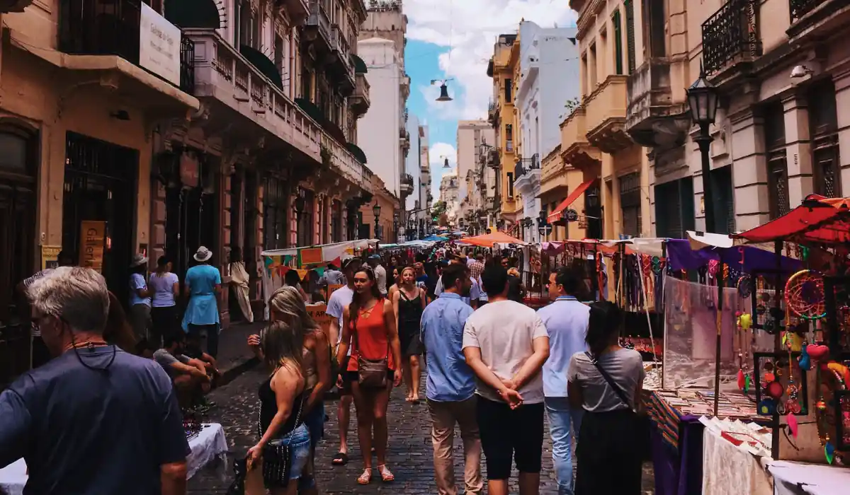 40 amazing Cute Date Ideas in Columbus, Ohio for Couples in 2025 13 A bustling street market with people walking among colorful stalls displaying various goods. Historic buildings line the narrow street under a bright blue sky. Shoppers and vendors mingle, creating a lively atmosphere.