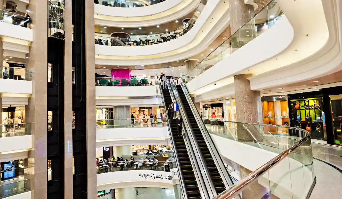 Top 15+ Free Things to do in Atlanta for Couples 2025 6 A multi-level shopping mall interior with modern architecture. Escalators connect the floors, and glass railings line the walkways. Stores with colorful displays are visible, and people are browsing and moving throughout the scene.