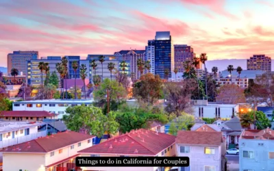 20 Most Romantic Things to do in California for Couples A vibrant cityscape of California at sunset, featuring tall buildings and palm trees with a foreground of residential houses. The sky is painted in hues of pink and orange. A banner reads, Things to do in California for Couples.