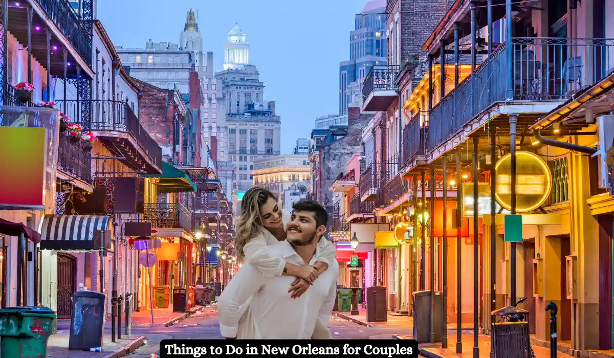 The 15 Best Things to Do in New Orleans for Couples 2 A happy couple is enjoying a piggyback ride on a lively street in New Orleans. The scene features colorful buildings, vibrant lights, and a backdrop of tall city structures, creating a romantic, energetic atmosphere. Text reads, Things to Do in New Orleans for Couples.