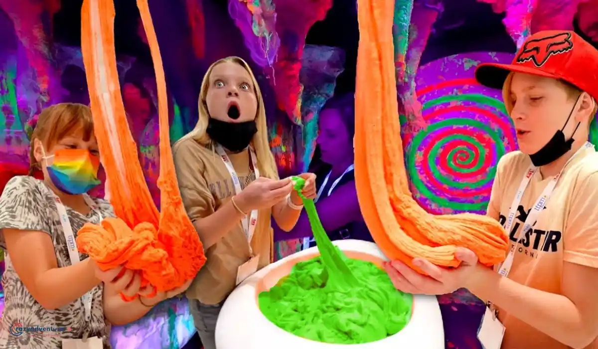 The 10 Best Interactive Museums in NYC You Must Visit  3 Three children stretch bright orange and green slime in a colorful, vibrant setting with neon spirals and cave-like textures in the background. One child looks amazed while the others focus on the slime.