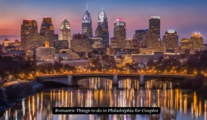 A nighttime view of Philadelphias skyline with brightly lit skyscrapers. The city lights reflect on the river below, and a bridge is visible in the foreground. The sky is a gradient of blue and orange. Text reads, Romantic Things to do in Philadelphia for Couples.