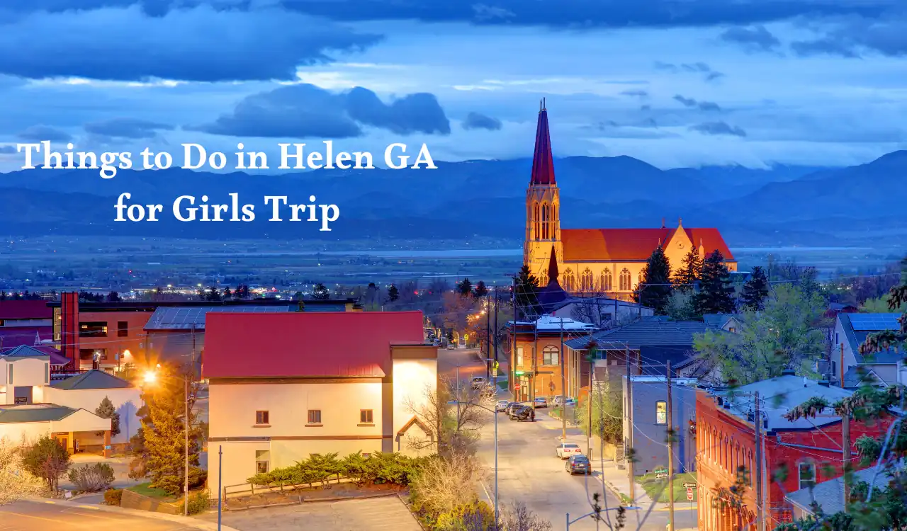A picturesque view of Helen, Georgia, at dusk with illuminated buildings, a prominent church, and distant mountains. Text overlay reads Things to Do in Helen GA for Girls Trip. Top 10+ Romantic Things to Do in Helen GA for Girls Trip