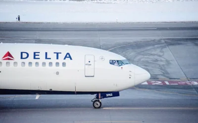 Exclusive Delta Flight Dog Diversion MSP Shocks Travelers (2025) A Delta Air Lines airplane taxiing on a runway, photographed from the side, with snow visible in the background.